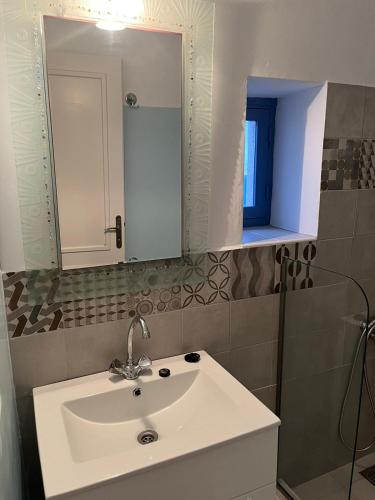 a bathroom with a white sink and a mirror at Almira Studios and Apartments in Agia Marina