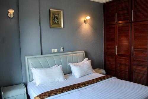 a bedroom with a bed with two pillows on it at Residence Le Carat Bonapriso in Douala