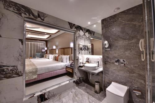 una camera d'albergo con bagno dotato di letto e lavandino di The Fern Shelter Resort Palghar a Manor