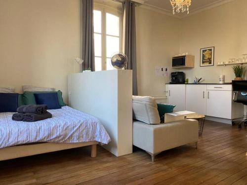 1 dormitorio con 1 cama y 1 silla y cocina en #Le Maitre du Navire - Grand Studio - Hyper centre, en Brive-la-Gaillarde