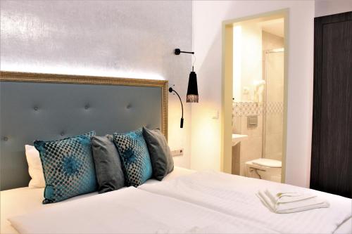 a bedroom with a white bed with blue pillows at Hotel Memories Budapest in Budapest