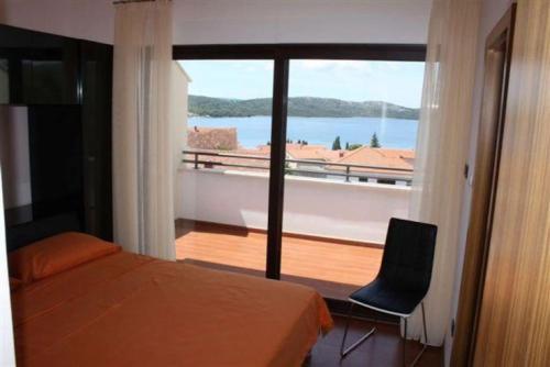 um quarto com uma cama e vista para uma varanda em Villa Bruna em Trogir