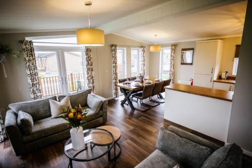 a living room with two couches and a table at Ream Hills Holiday Park in Blackpool