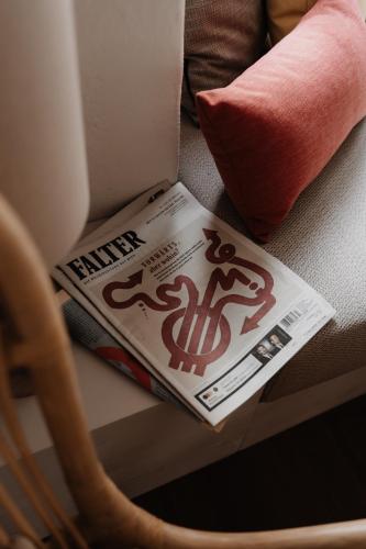 a magazine sitting on a chair next to a pillow at Leuchtenburg am See in Caldaro