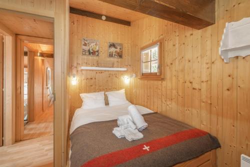 a bedroom with a bed in a wooden cabin at Chalet La Dame Blanche - Cosy Family Chalet - up to 8 people in La Tzoumaz