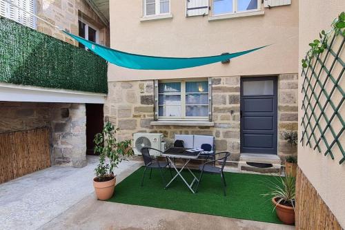eine Terrasse mit einem Tisch und Stühlen vor einem Gebäude in der Unterkunft #Le Rue des 2 Porches #F2 avec Cours #HyperCentre in Brive-la-Gaillarde