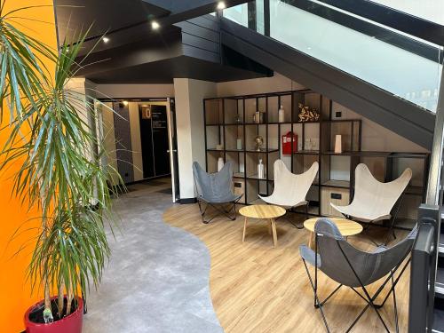 a lobby with white chairs and a table and shelves at ibis Saint-Lô in Saint Lo