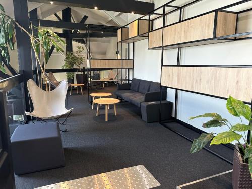 an office with a couch and chairs and plants at ibis Saint-Lô in Saint Lo