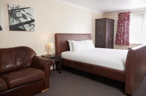 a hotel room with a bed and a chair at Farmhouse Innlodge by Greene King Inns in Portsmouth