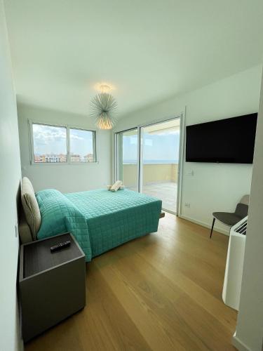a bedroom with a bed and a couch and a tv at Gli Scogli Luxury Residence Hotel in Chiavari