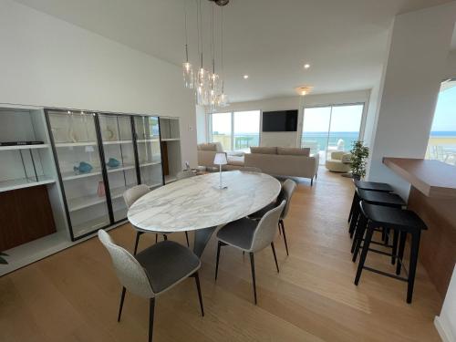 a dining room and living room with a table and chairs at Gli Scogli Luxury Residence Hotel in Chiavari
