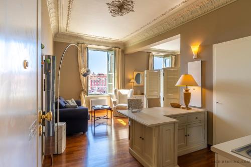 una cucina e un soggiorno con divano e tavolo di Nice Renting - 13 MASSENA - Live A Dream Luxury Loft - Place Massena a Nizza