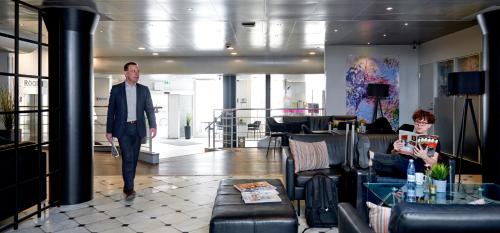 a man in a suit walking through a lobby at Cabinn Scandinavia in Copenhagen