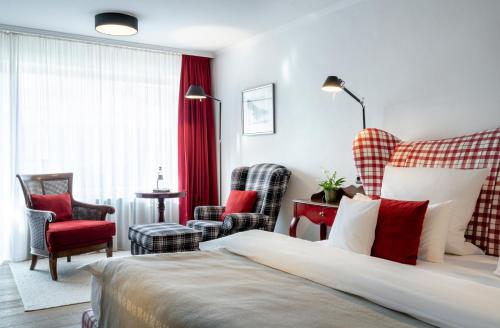 a hotel room with a bed and two chairs at Hotel Franks in Oberstdorf