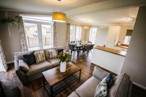 a living room with a couch and a table at Ream Hills Holiday Park in Blackpool