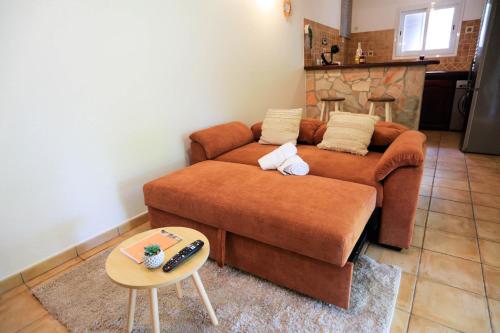 un soggiorno con divano marrone e tavolo di Studio Arc-en-ciel a Sainte-Anne
