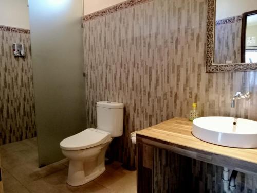 une salle de bain avec toilettes et lavabo dans l'établissement Yudis Guest House, à Ubud