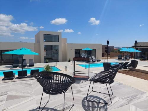 un patio con sillas y sombrillas y una piscina en D'VINO Valle De Guadalupe, en Ensenada