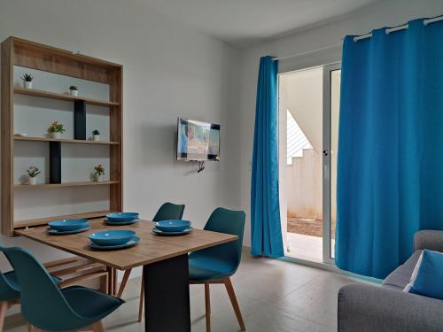 comedor con mesa y sillas azules en Marzamemi - Appartamento Girasole al Borgo 84, en Marzamemi