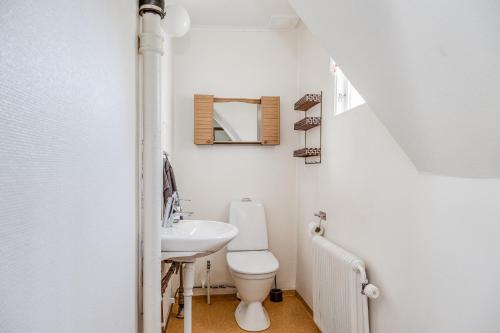a white bathroom with a toilet and a sink at Lovely holiday home with a sea view in Oskarshamn