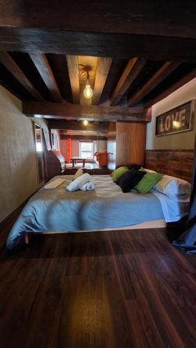 ein großes Bett in einem Zimmer mit Holzdecke in der Unterkunft LOFT LA CATEDRAL DE CASA BOTES in Cuenca