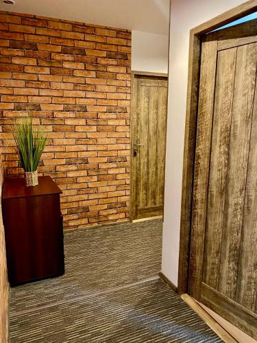 an empty room with a brick wall and a door at Old Tree Home & Restaurant in Oświęcim