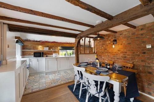 a kitchen and dining room with a brick wall at Charming, dog friendly cottage in Doddington