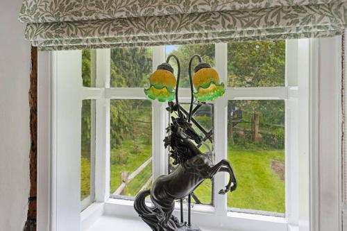 a statue of a horse in front of a window at Charming, dog friendly cottage in Doddington