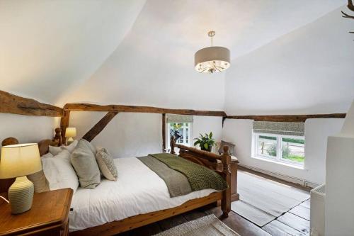 a bedroom with a bed and a table and a lamp at Local Walks Pub Gardens Pet Friendly Landscaped Gardens and Free Private Parking in Doddington