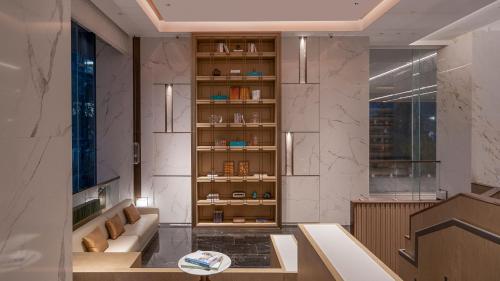 Habitación con estante para libros y sofá en Crowne Plaza Hangzhou Linping, an IHG Hotel, en Hangzhou