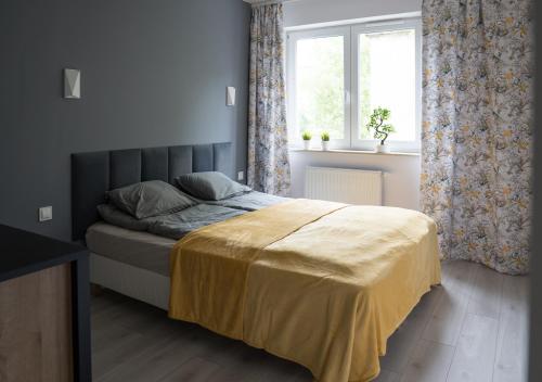 Un dormitorio con una cama con una manta amarilla. en Apartament Wiosenny Kamienica Grochów with free parking, en Varsovia