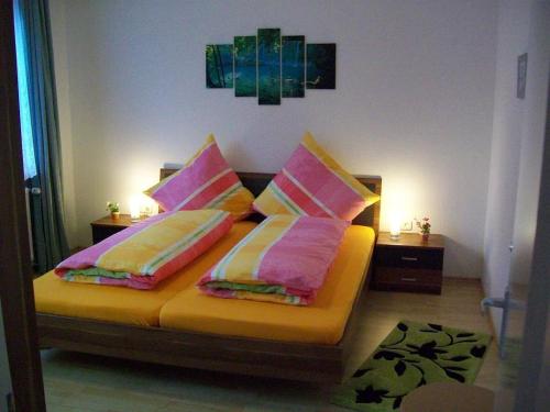 a bedroom with a bed with pink and yellow pillows at Dogge, Ferienwohnung in Celle