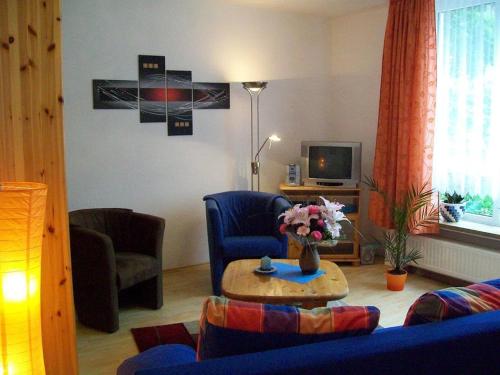 ein Wohnzimmer mit einem blauen Sofa und einem Tisch in der Unterkunft Dogge, Ferienwohnung in Celle