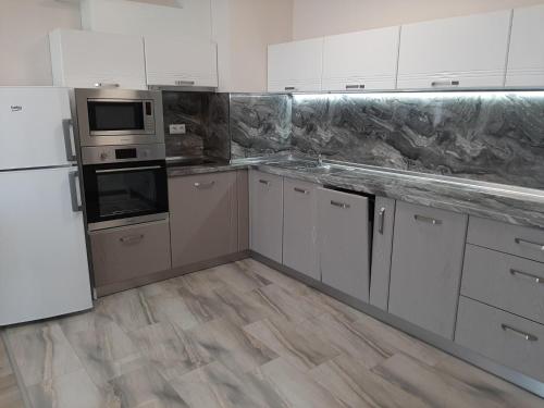 eine Küche mit weißen Geräten und Holzböden in der Unterkunft Апартамент Deluxe 6 in Sweti Konstantin