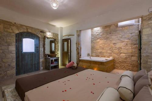 una grande camera con vasca da bagno e divano di Διαμέρισμα Villa Iro a Mátala