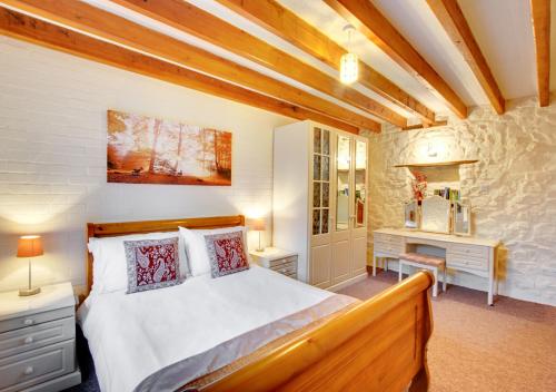 a bedroom with a large bed and a stone wall at Swallow Cottage in Haverfordwest
