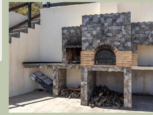 an outdoor oven with a stone wall and stairs at Las vistas del valle in Hontoba