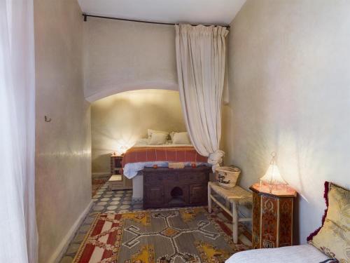 a bedroom with a bed and a chair and a table at DAR AL AMAL in Marrakesh