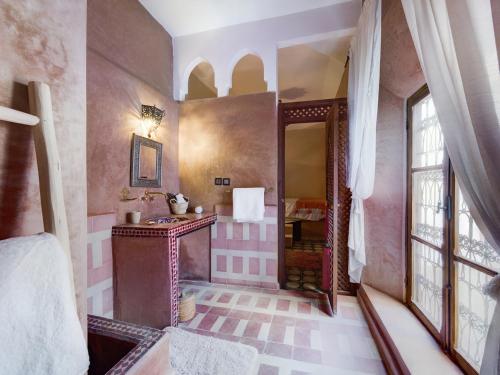 a bathroom with pink and white walls and a mirror at DAR AL AMAL in Marrakesh