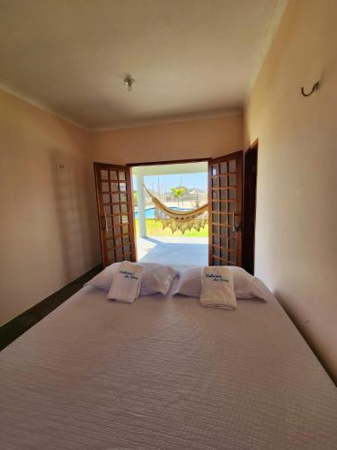 ein Schlafzimmer mit einem Bett und zwei Kissen darauf in der Unterkunft Cabanas da Sorte in Fortim