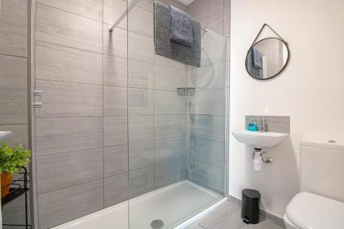 een badkamer met een douche, een toilet en een wastafel bij No.89 Stylish Ground Floor Apartment in Paignton