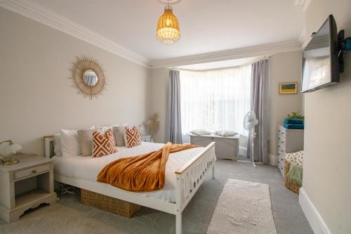 een slaapkamer met een wit bed en een raam bij No.89 Stylish Ground Floor Apartment in Paignton
