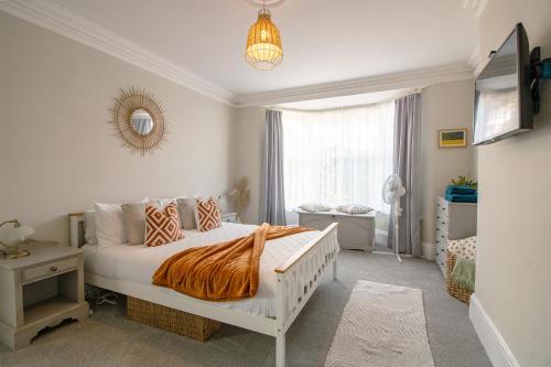 a bedroom with a white bed and a window at No.89 Stylish Ground Floor Apartment in Paignton