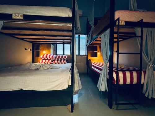 1 Schlafzimmer mit 2 Etagenbetten und 1 Bett mit einem Kissen in der Unterkunft Por Chey Hostel in Battambang