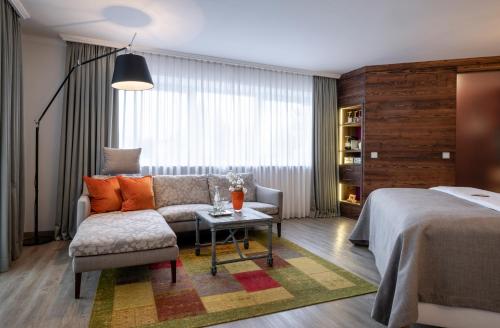 1 dormitorio con cama, sofá y mesa en Hotel Franks, en Oberstdorf