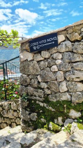 a stone wall with a blue sign on it at Casa Vita Nova in Perast