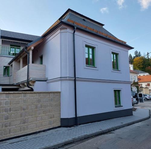 a white building on the side of a street at Apartmány Phlora in Lysice