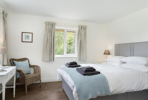 a bedroom with a bed and a chair and a window at Strawberry Lodge 