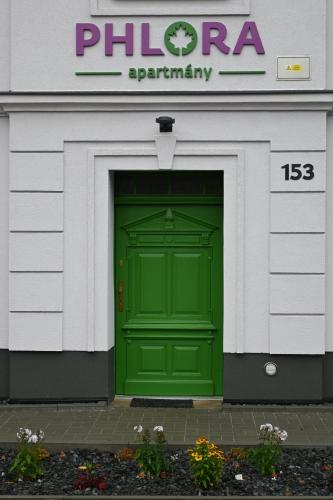 una puerta verde en la parte delantera de un edificio en Apartmány Phlora en Lysice