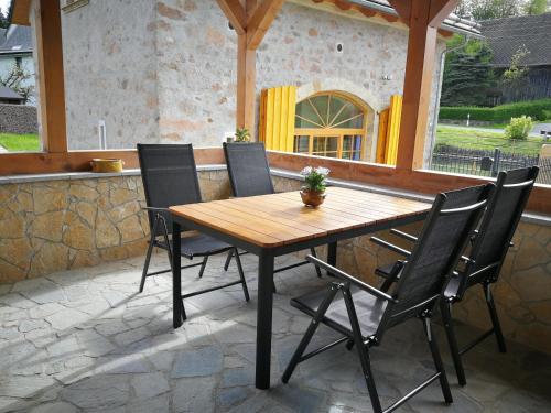 einen Holztisch und vier Stühle auf einer Terrasse in der Unterkunft Ferien in der alten Scheune in Kurort Altenberg